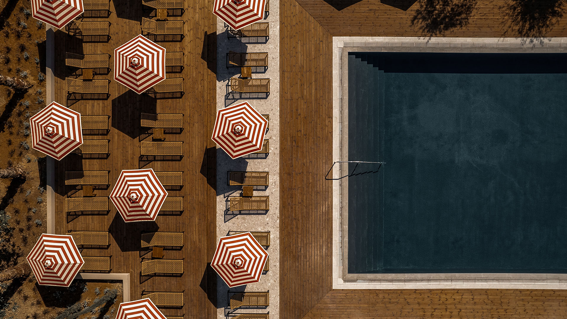 Hotel pool with geometric layout and striped umbrellas, strong visual composition