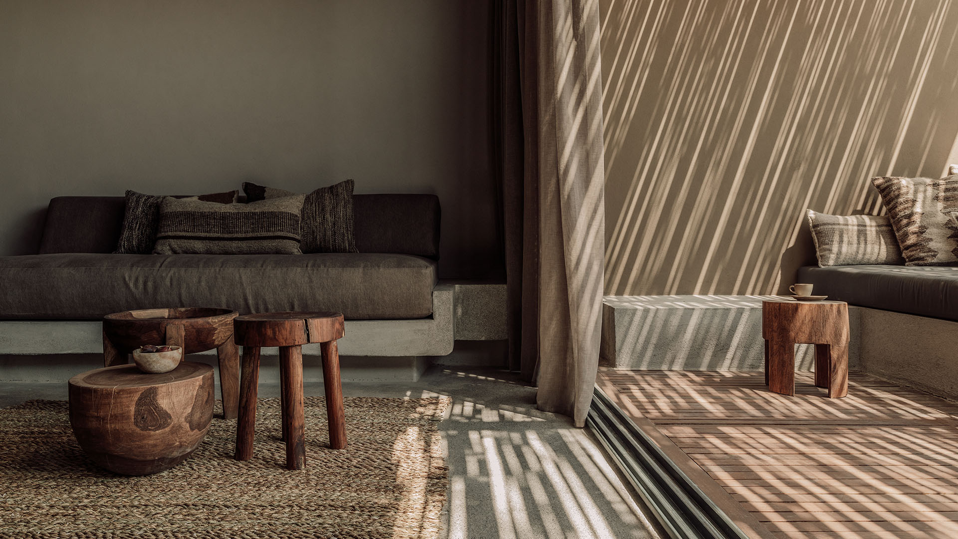 Sunlit hotel living area with textured materials and soft shadows, relaxed atmosphere