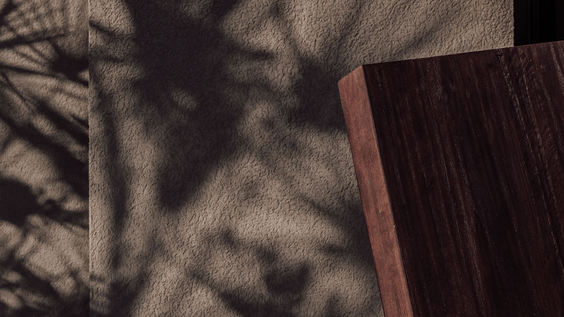 Textured stone wall and natural wood surfaces in calm minimalist hotel design