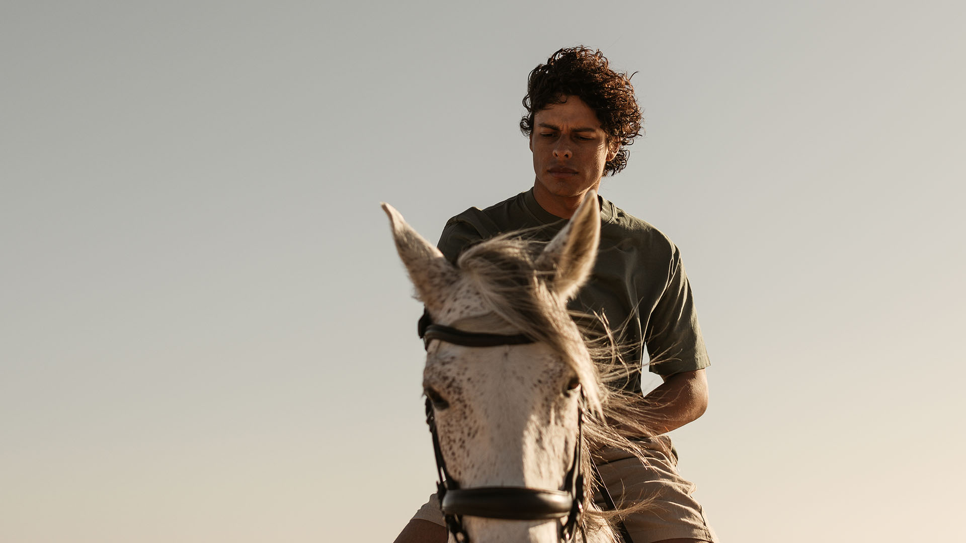 Young man riding a horse in natural landscape, reflecting outdoor lifestyle experience at a resort destination