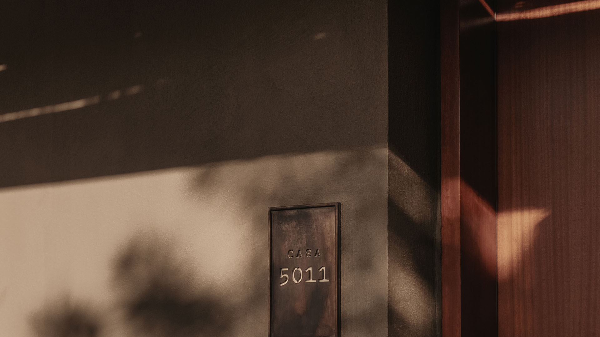 Hotel entrance with natural materials and warm sunlight, welcoming architectural atmosphere