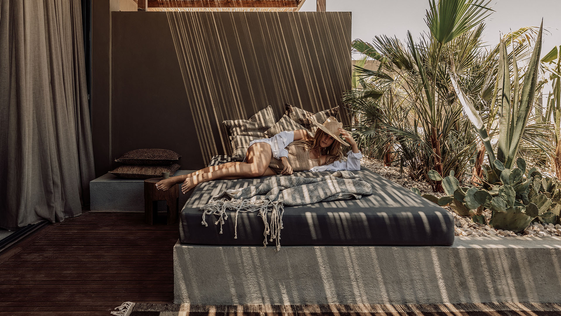 Private outdoor daybed at a hotel with plants and natural materials, quiet retreat space 