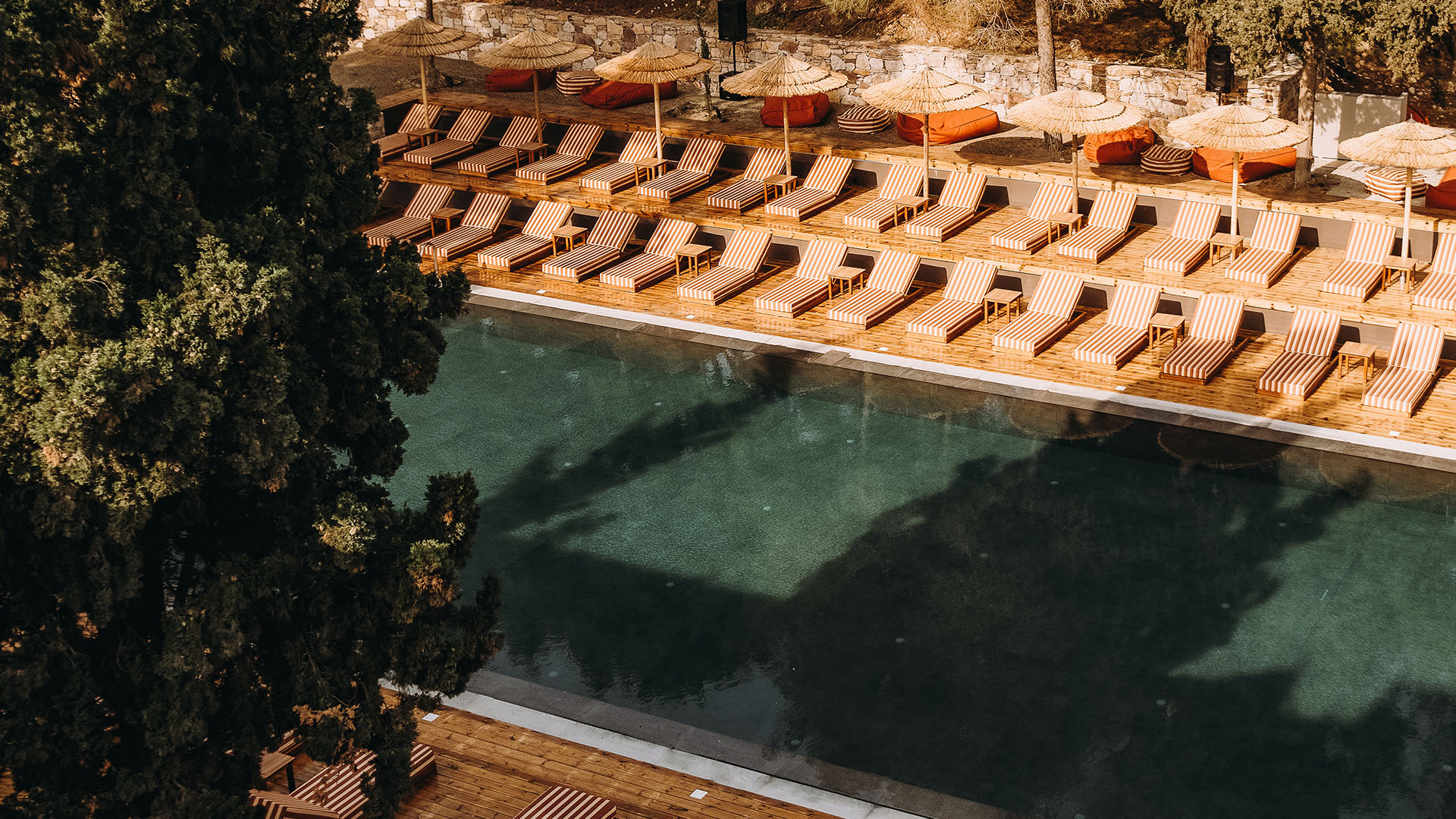 Cooks Club hotel pool area with loungers and parasols in warm tones